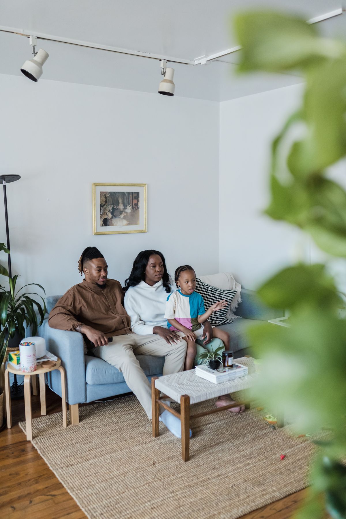 Une famille regarde la télévision ensemble dans un salon clair